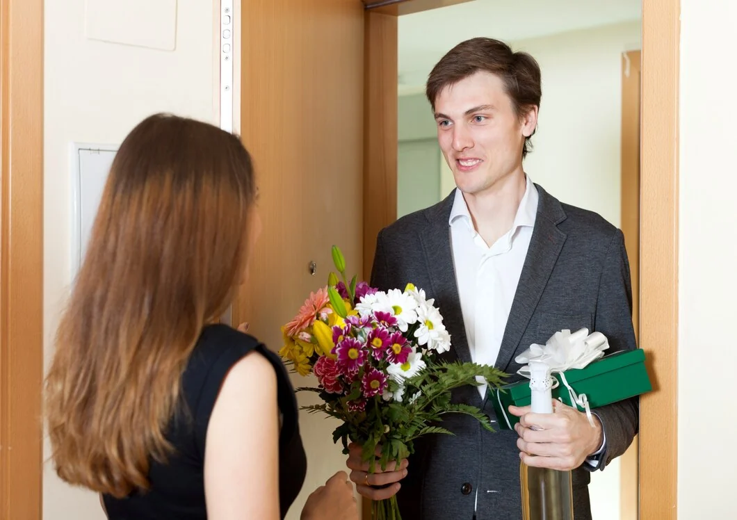 Man presenting a colorful bouquet at a doorway