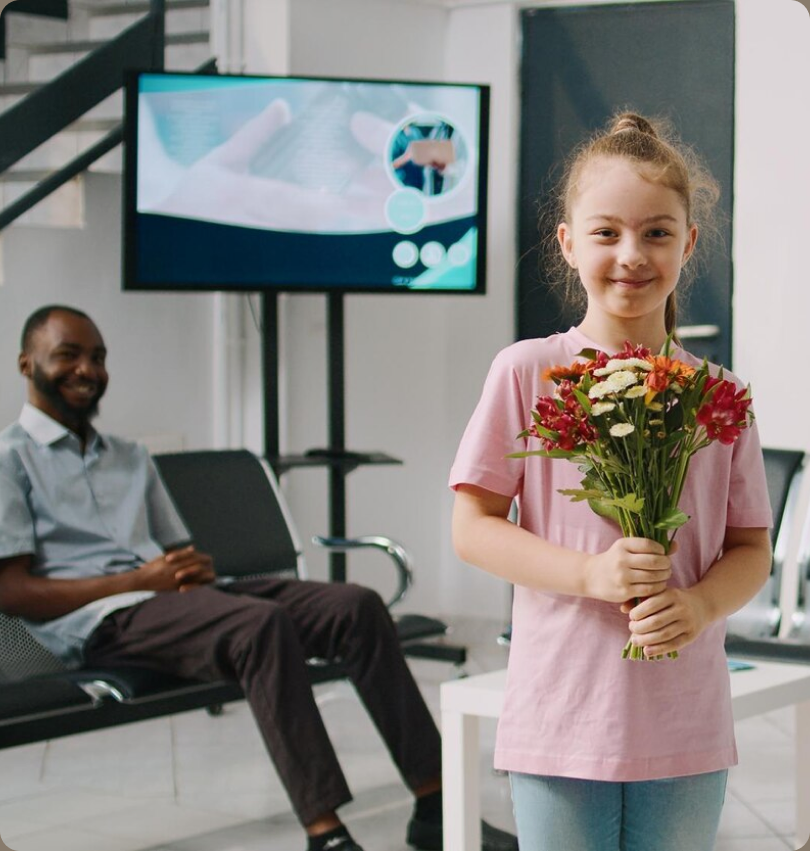 Child holding flowers in a hospital waiting room