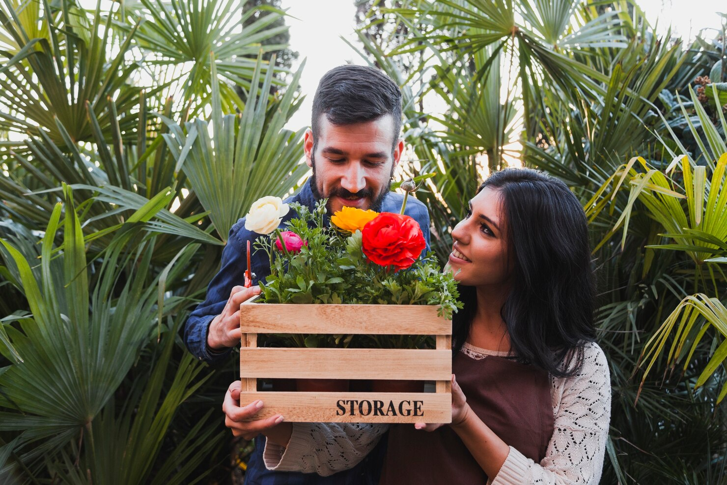 Couple holding a crate of fresh flowers